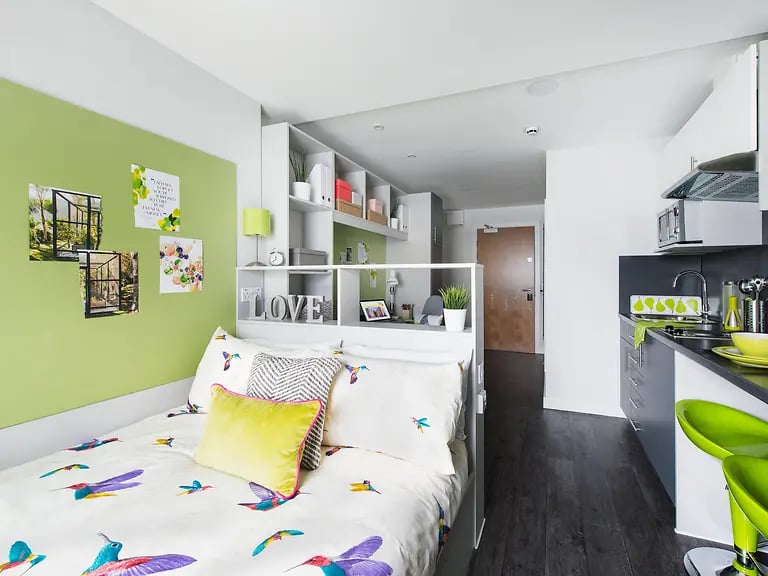 Bed with hummingbird print and modern kitchenette living room at Yugo Austen House in Southampton Student Accommodation