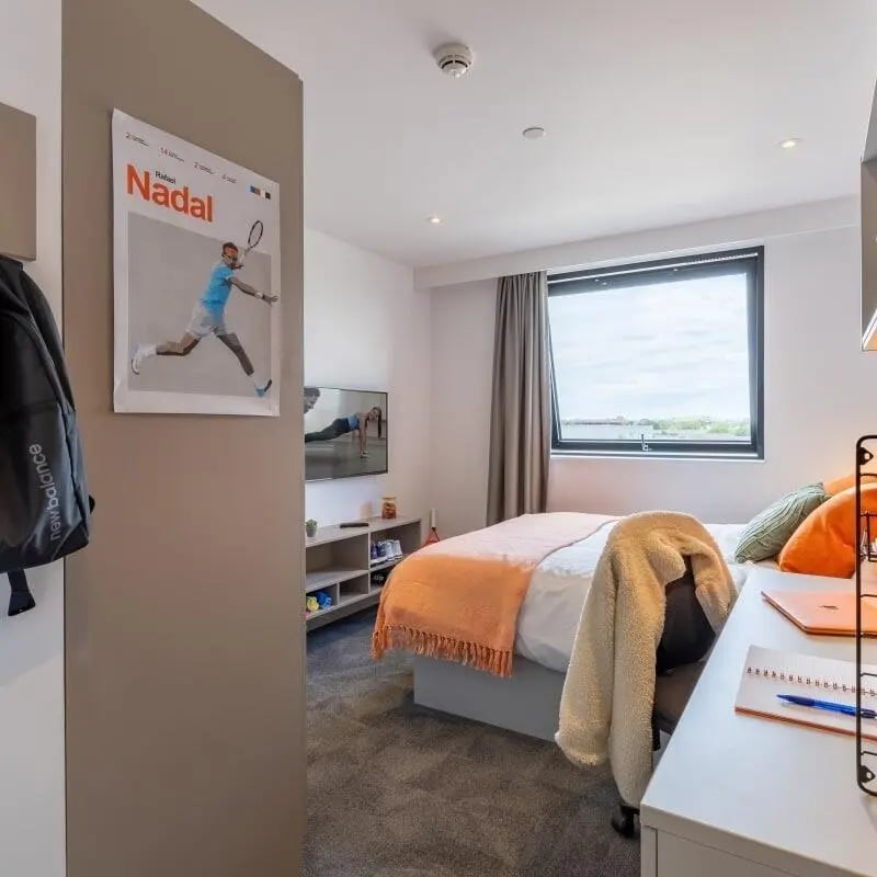 Bed with orange throw and desk bedroom at True Swansea in Swansea Student Accommodation