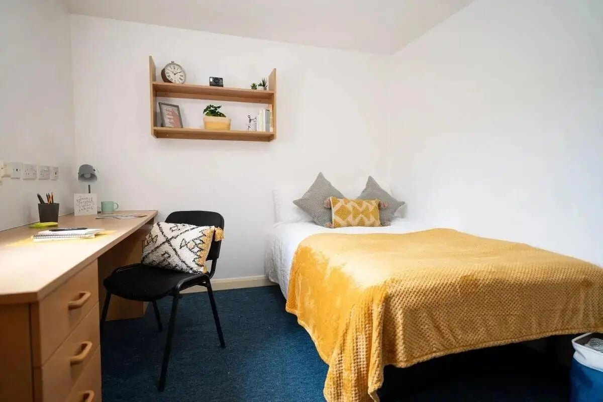 Bed desk chair shelf with items bedroom at Moor Lane Halls in Preston Student Accommodation