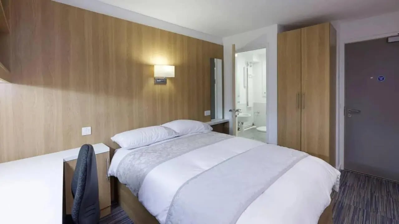 Bed desk wardrobe and bathroom view bedroom at Treliske Key Workers in Truro Student Accommodation
