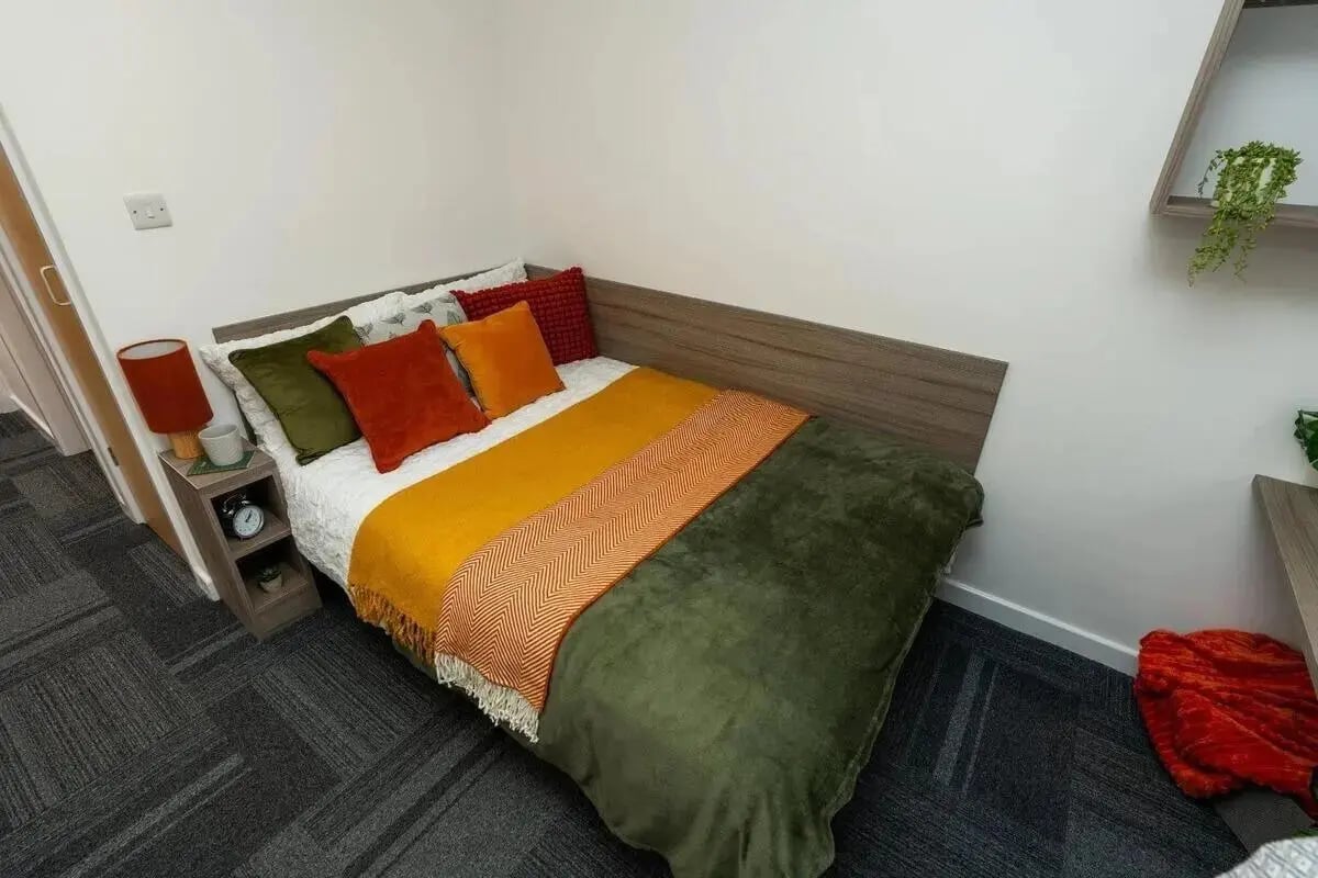 Bed with colorful pillows and throws bedroom at Tramways - Salford in Salford Student Accommodation