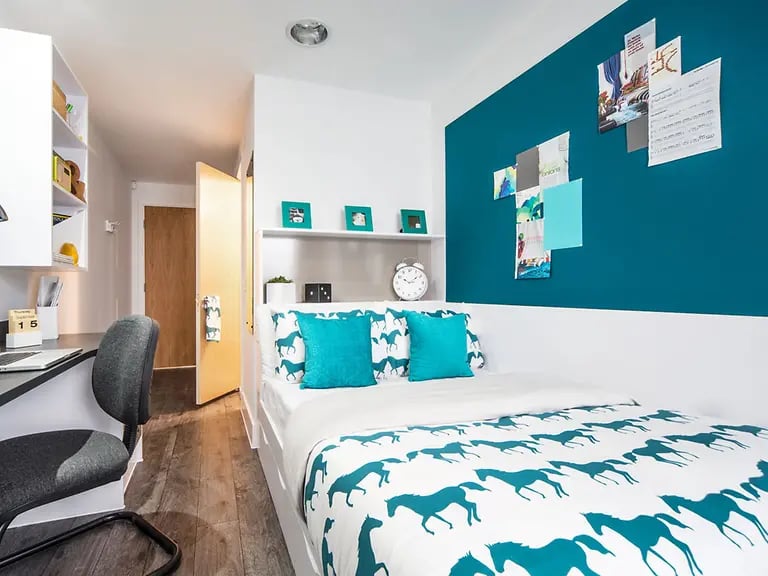 Bed desk shelves door and teal wall bedroom at Yugo Canal Point in Edinburgh Student Accommodation
