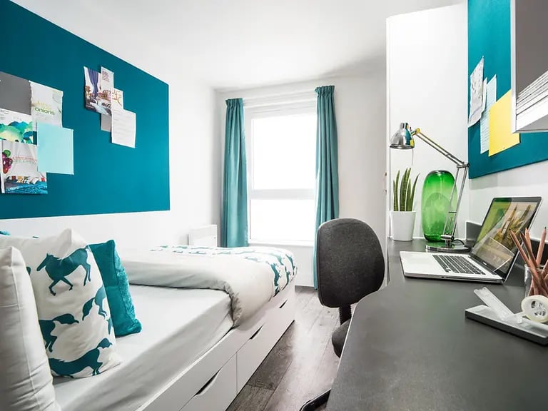 Bed with horse pillows desk lamp laptop study area at Yugo Canal Point in Edinburgh Student Accommodation
