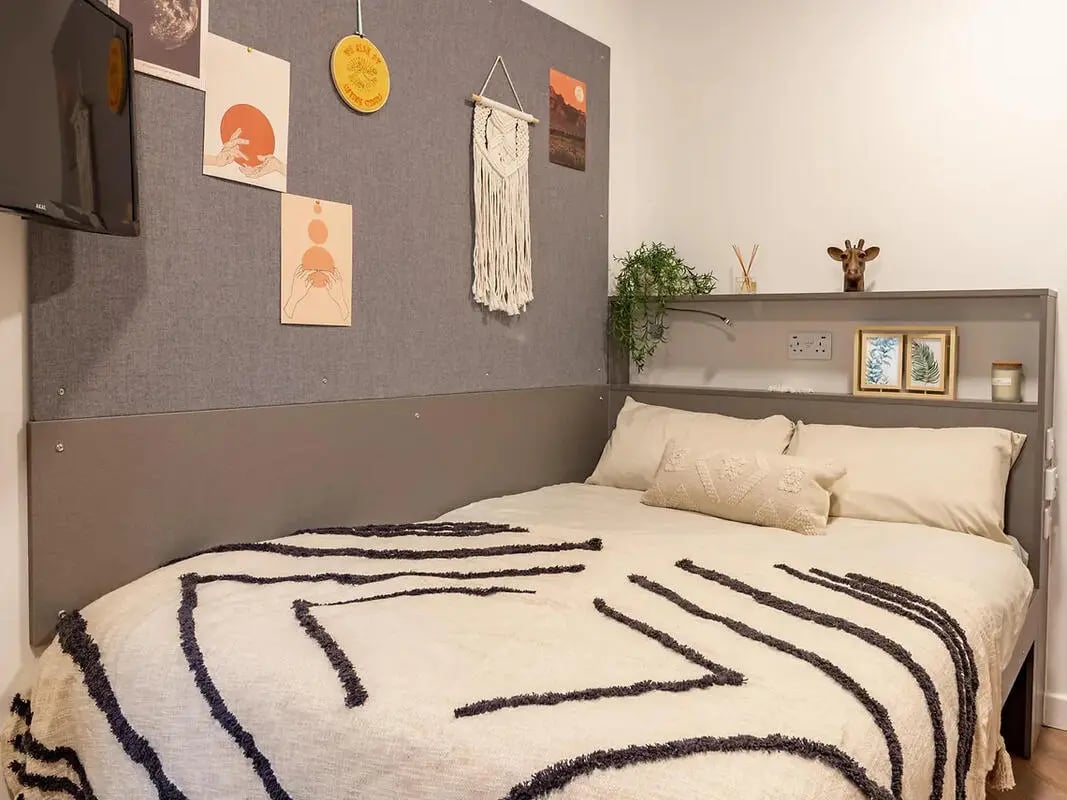 Bed with patterned throw bedside shelf bedroom at Yugo Belaton House in Bournemouth Student Accommodation