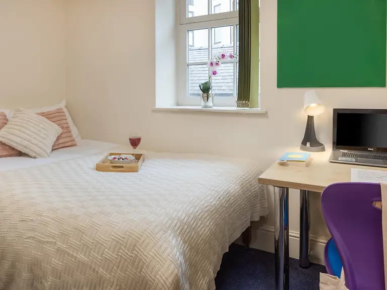 Bed tray with fruit and drink laptop on desk bedroom at Cable Street Lancaster in Lancaster Student Accommodation