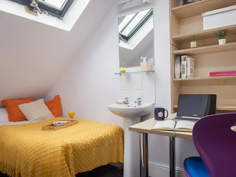 Bed desk sink bookshelf with laptop and purple chair bedroom at Cable Street Lancaster in Lancaster Student Accommodation