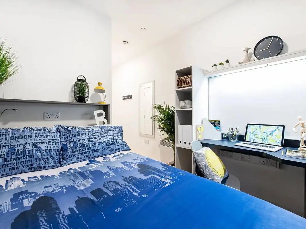 Bed study area with laptop and shelves Bedroom at Yugo Belaton House in Bournemouth Student Accommodation