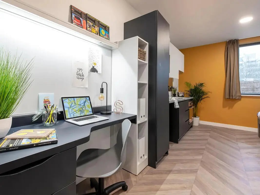 Desk laptop chair and kitchen area studio at Yugo Belaton House in Bournemouth Student Accommodation