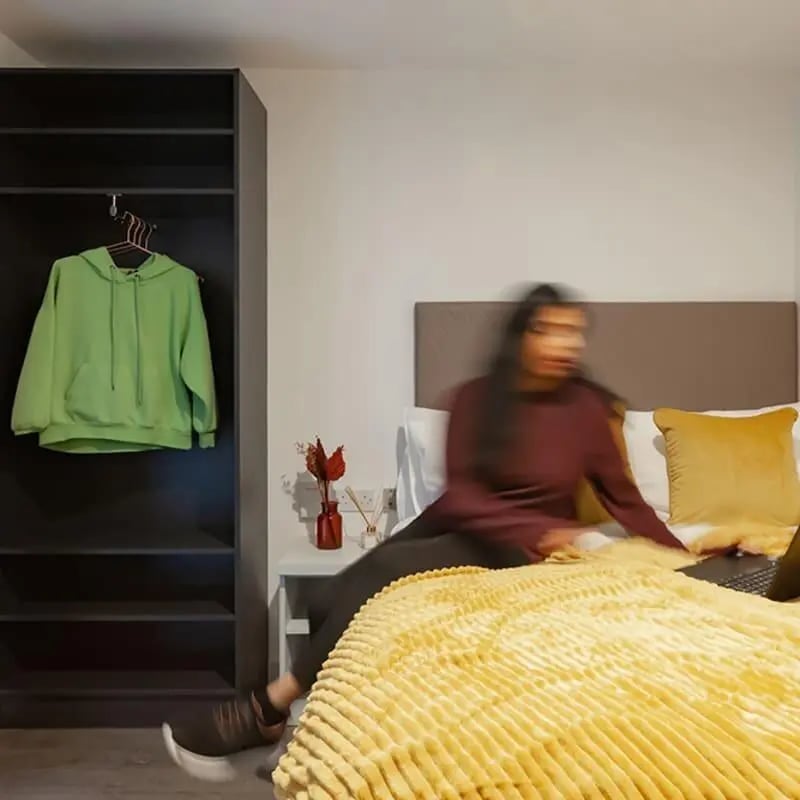 Green hoodie on closet bed yellow blanket bedroom at True Liverpool in Liverpool Student Accommodation