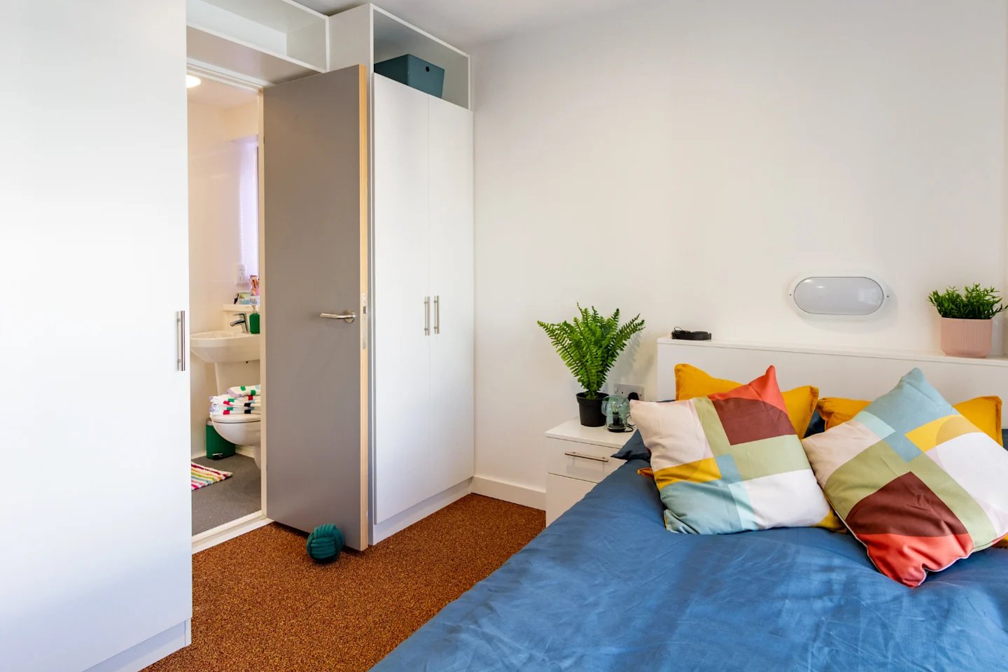 Bed pillows wardrobe plants open bathroom bedroom at The Shield in Newcastle Upon Tyne Student Accommodation