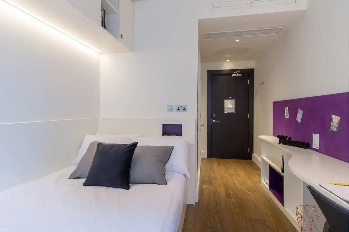 Bed with dark grey pillow on white bedding bedroom at Spring Mews in London Student Accommodation