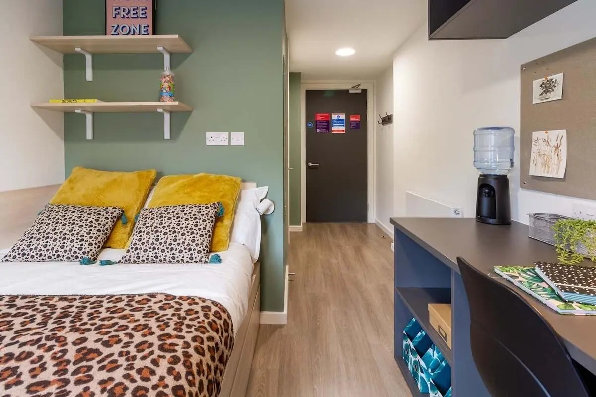 Bed with leopard print duvet and desk study area at Dun Holm House in Glasgow Student Accommodation