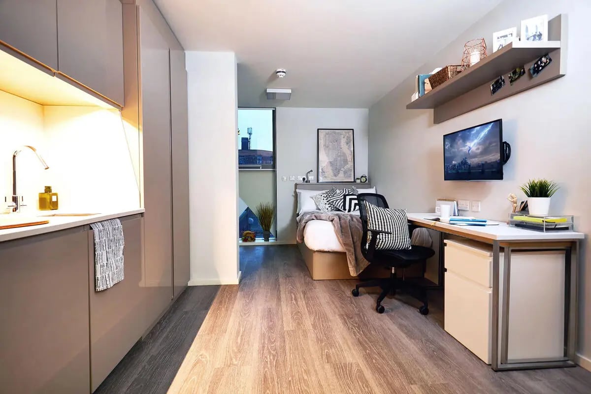 Kitchen sink bed desk chair and television studio apartment at Vita Student Manchester First Street in Manchester Student Accommodation