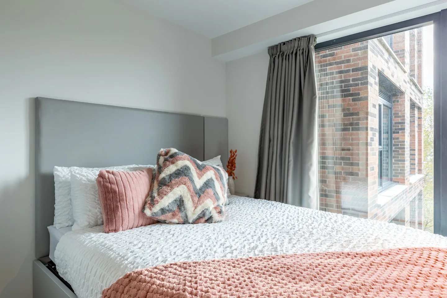 Bed with pillows and pink throw bedroom at Glasgow West-End in Glasgow Student Accommodation