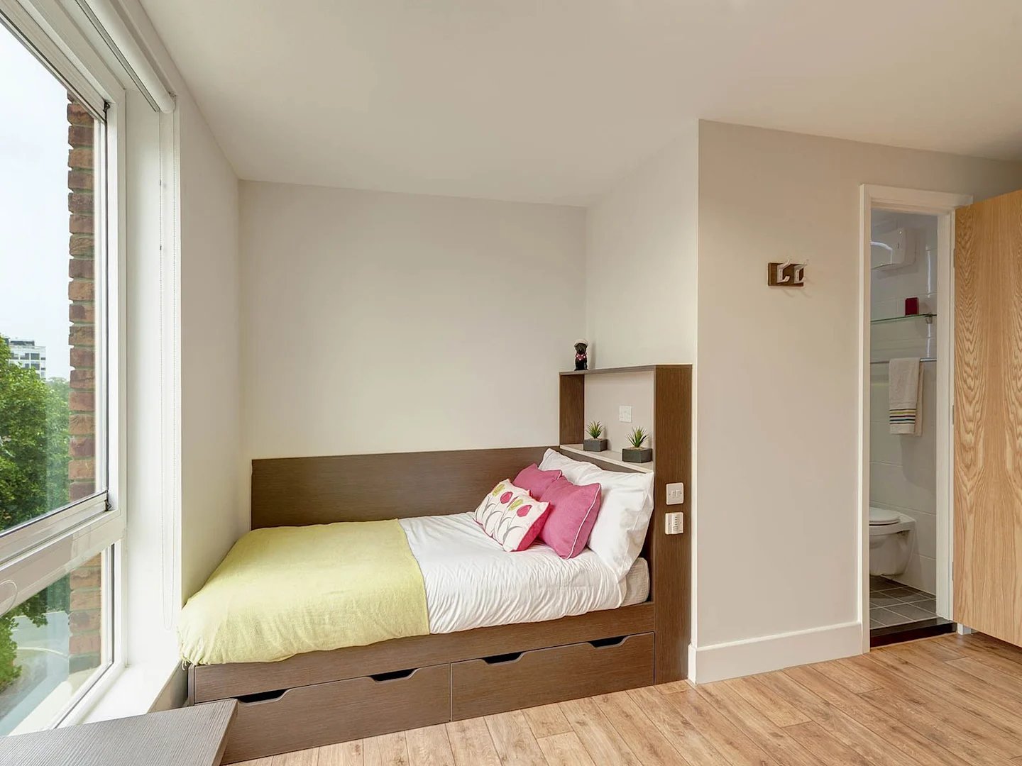 Bed with drawers and pink pillows bedroom at Davidson House in Kingston Upon Thames Student Accommodation