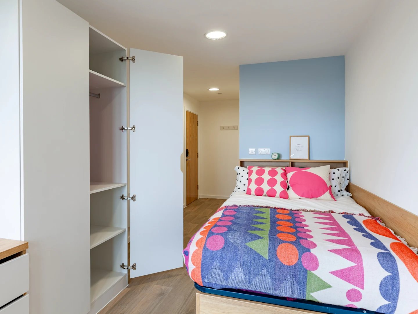 Wardrobe bed with colorful blanket and pillows bedroom at Ty Nant in Swansea Student Accommodation