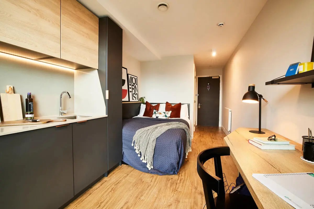 Bed desk and kitchen area Studio apartment at Vita Student Manchester Circle Square in Manchester Student Accommodation