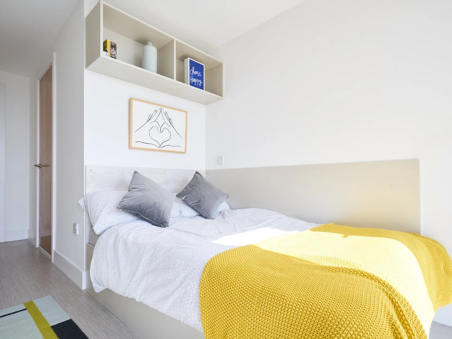 Bed with yellow throw art and shelves bedroom at The Lantern in Liverpool Student Accommodation