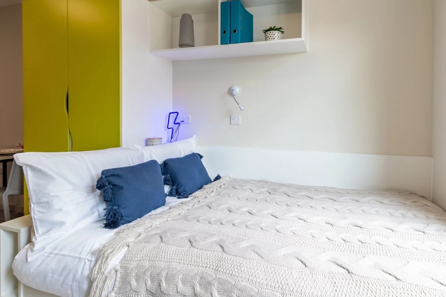 Bed with white linens blue pillows green wardrobe bedroom at The Barn in Exeter Student Accommodation