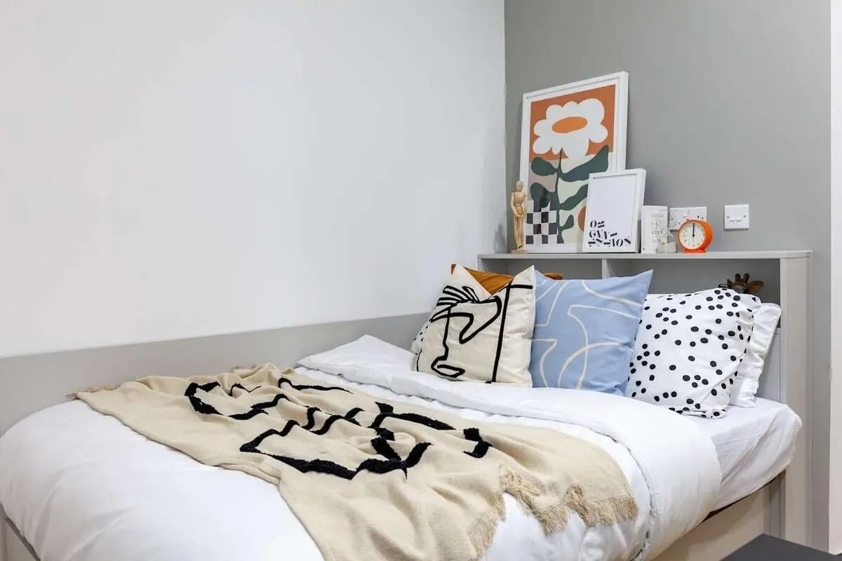 Bed with patterned pillows and throw bedroom at Radford Mill in Nottingham Student Accommodation