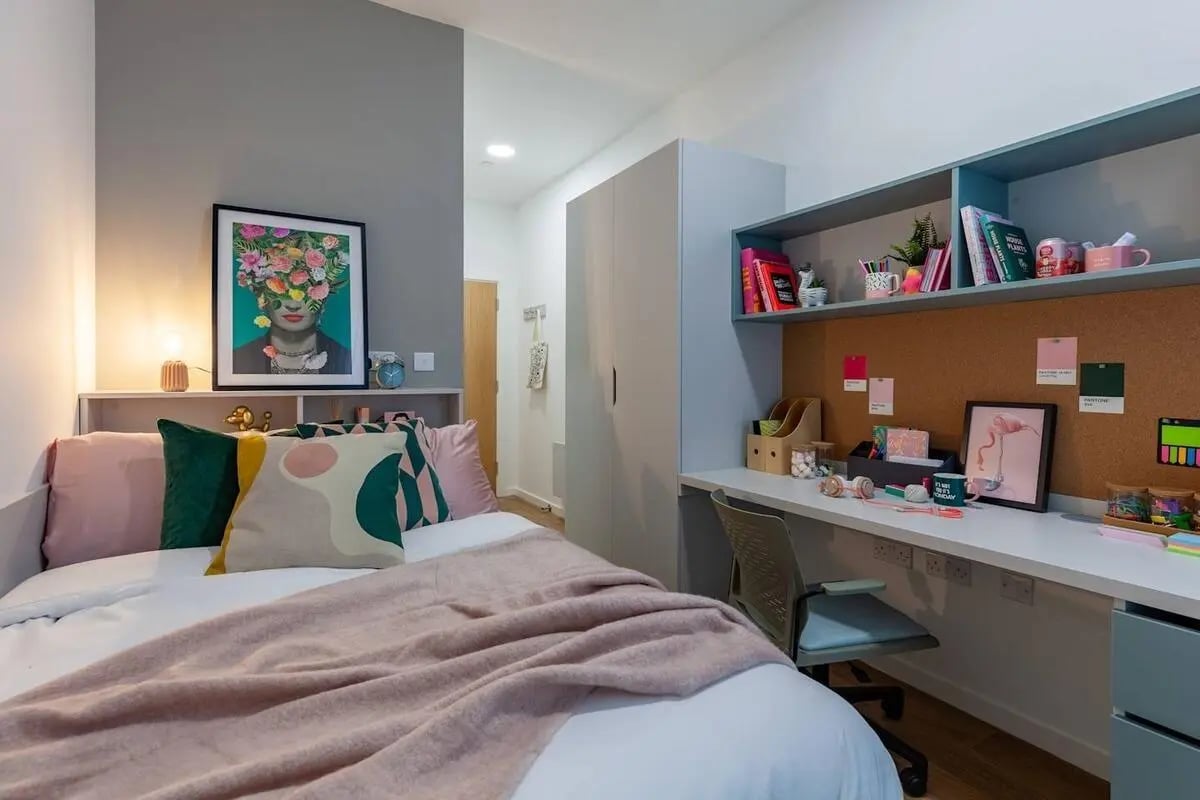 Bed with art and desk with Flamingo painting bedroom at Radford Mill in Nottingham Student Accommodation