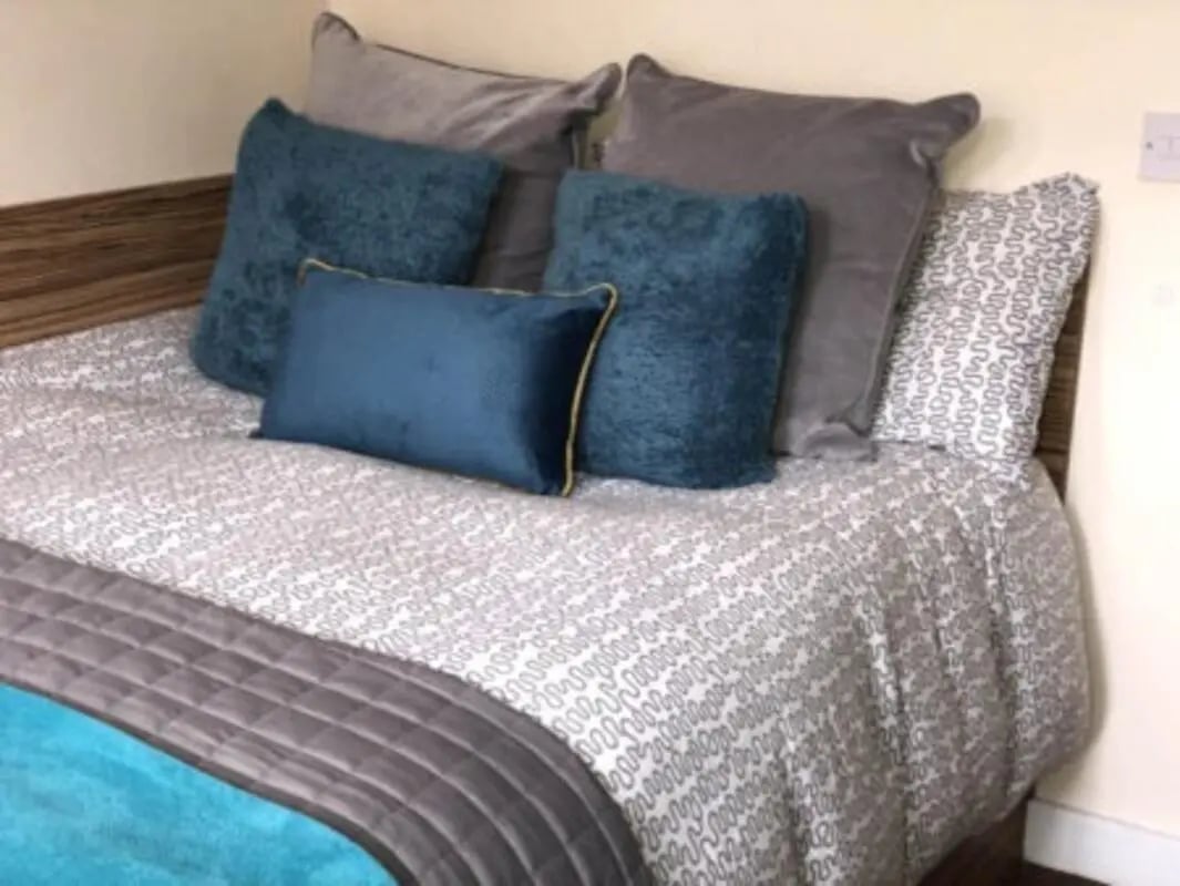 Bed with teal and grey pillows duvet bedroom at Waterside Court in Chester Student Accommodation