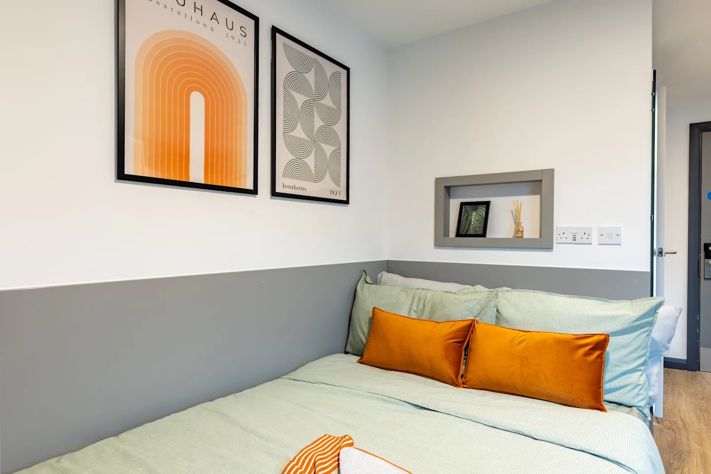 Bed with orange pillows modern art bedroom at Winfield Court in Nottingham Student Accommodation