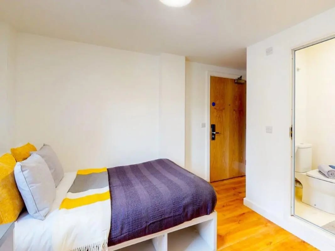 Bed with pillows blankets door toilet bathroom at The Cube in Bolton Student Accommodation