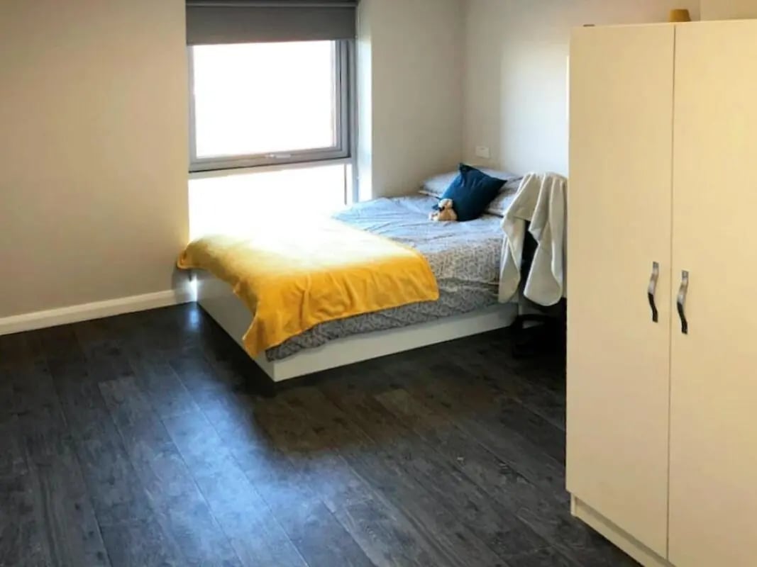 Bed with yellow blanket wardrobe bedroom interior at One Islington Plaza in Liverpool Student Accommodation