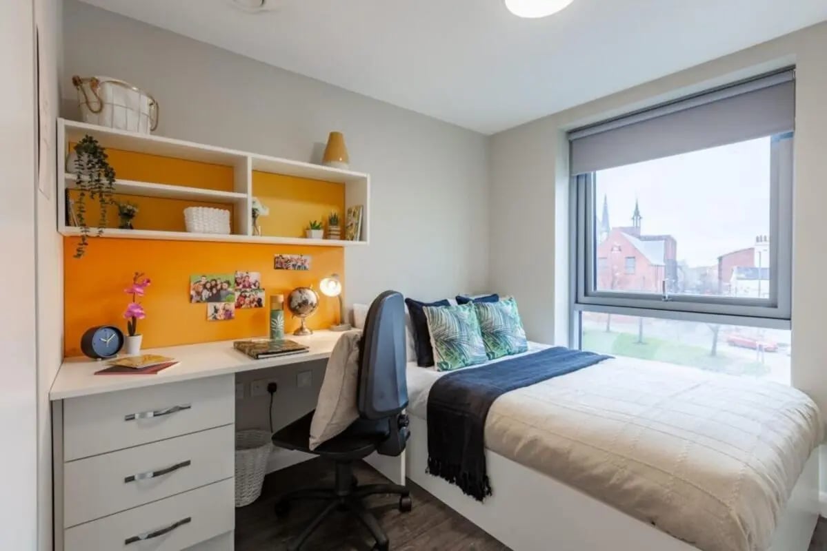 Desk bed chair with pillows window exterior bedroom at One Islington Plaza in Liverpool Student Accommodation