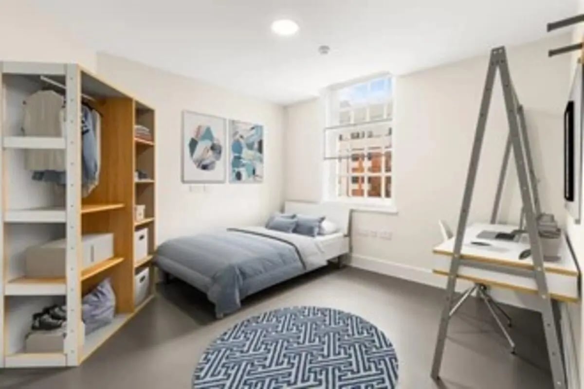 Wardrobe bed desk artwork circular rug bedroom at The Old Fire Station - Birmingham in Birmingham Student Accommodation