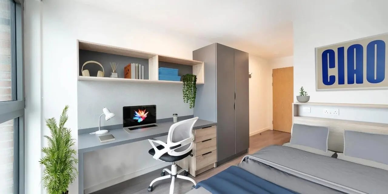 Desk chair laptop wardrobe bed and artwork bedroom at Canvas Glasgow in Glasgow Student Accommodation