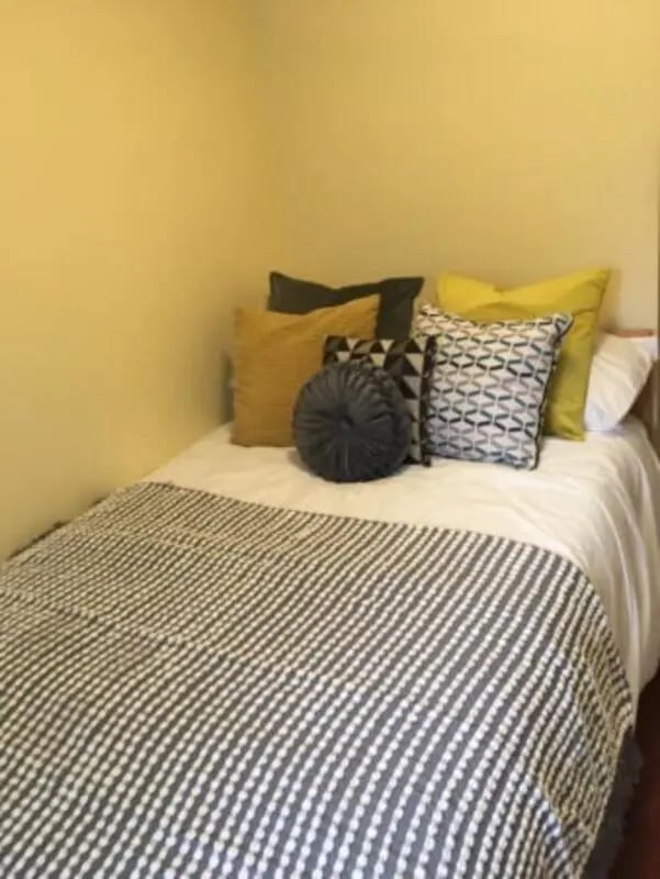 Bed with patterned throws and pillows bedroom at Longside House Bradford in Bradford Student Accommodation