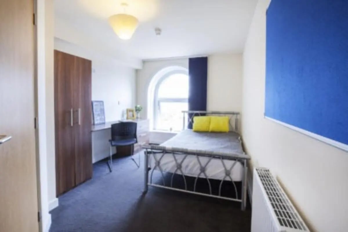 Bed desk wardrobe blue notice board bedroom at The Old Chapel in Huddersfield Student Accommodation