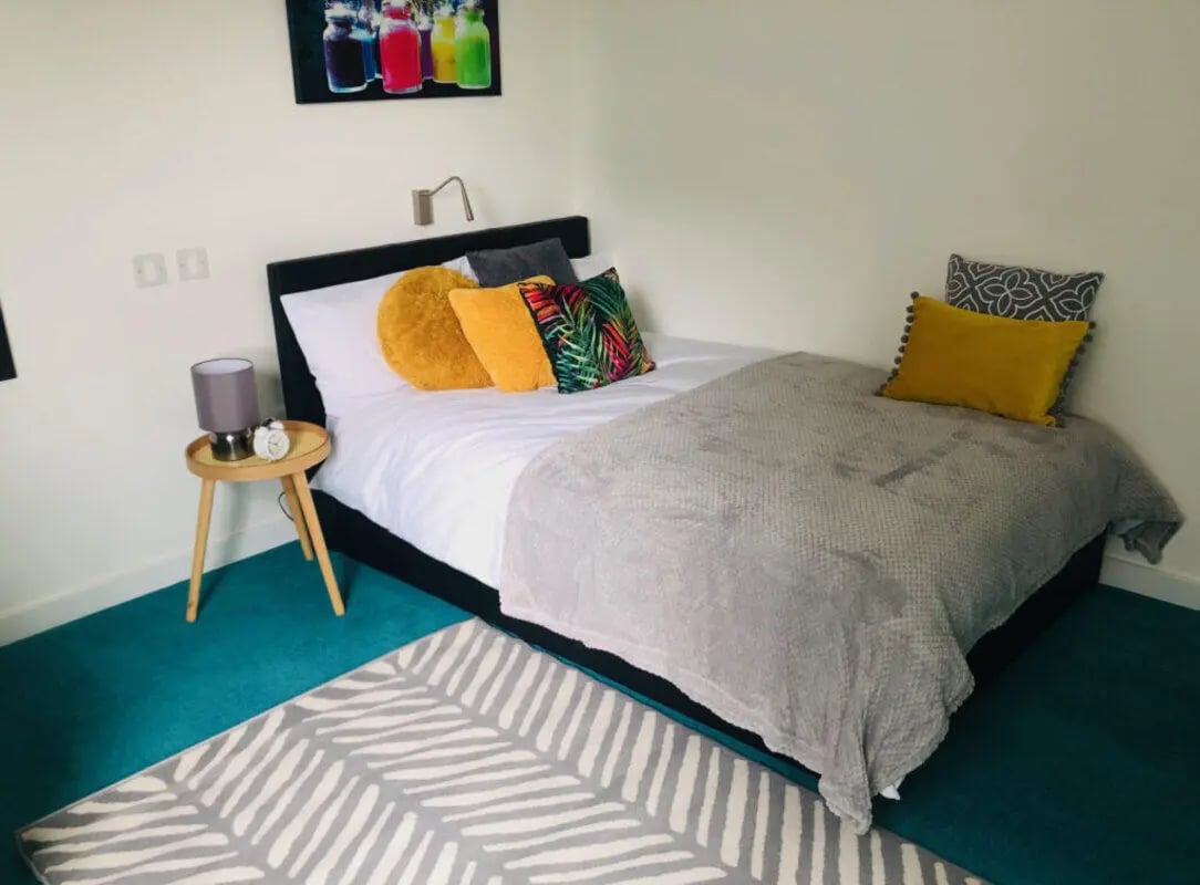 Bed with pillows rug lamp bedside table bedroom at Nebula in Sheffield Student Accommodation