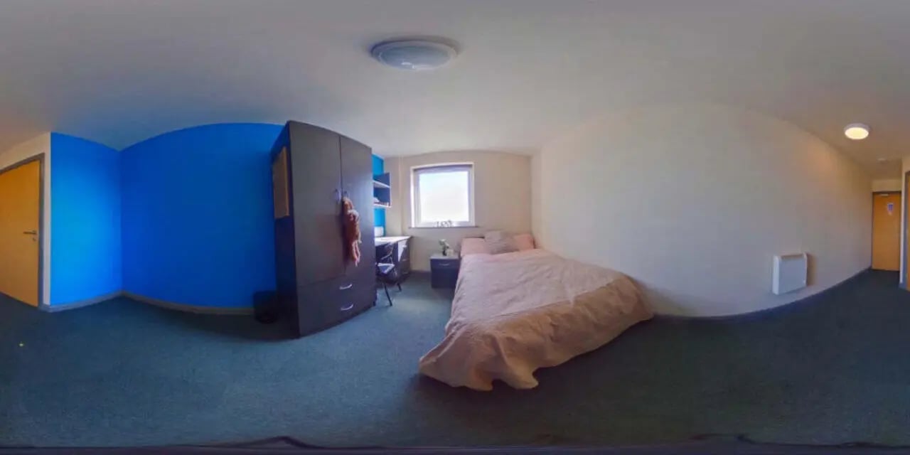 Bed wardrobe desk and blue walls bedroom at Stoke Student Village in Stoke-On-Trent Student Accommodation