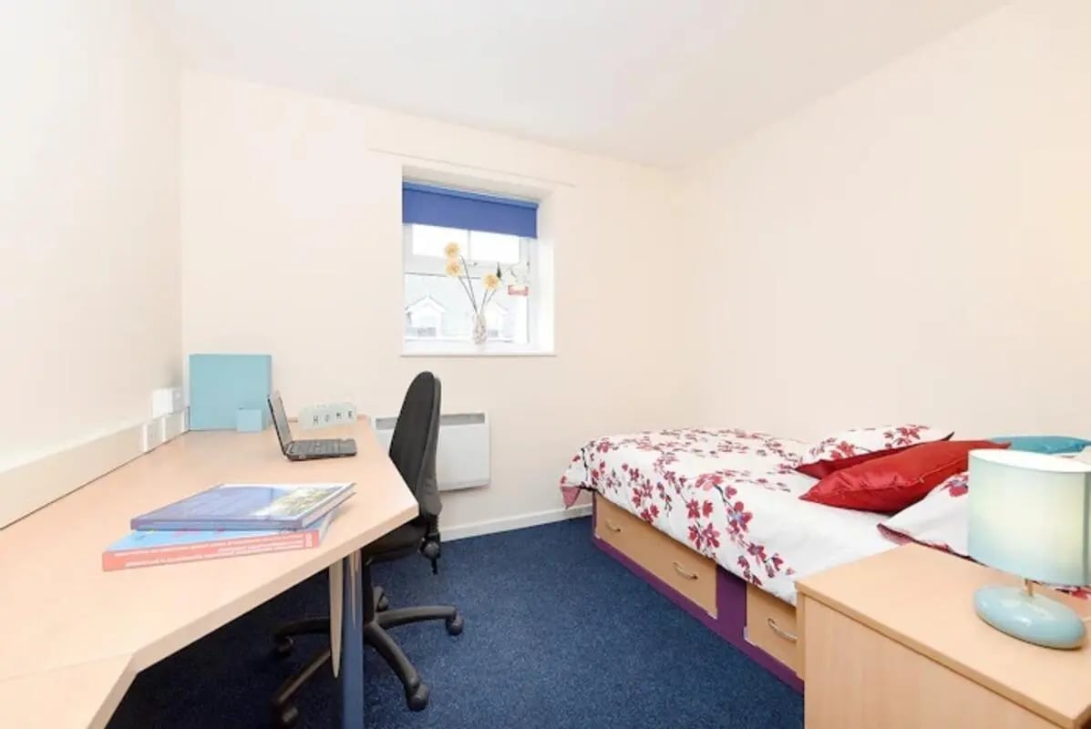 Bed desk chair laptop books and lamp bedroom at Snowdon Hall in Wrexham Student Accommodation