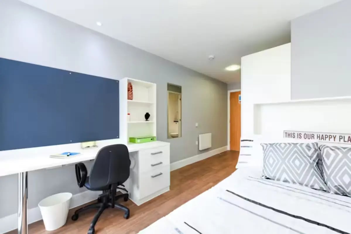 Desk chair whiteboard shelving and bed bedroom at Tramways in Chester Student Accommodation