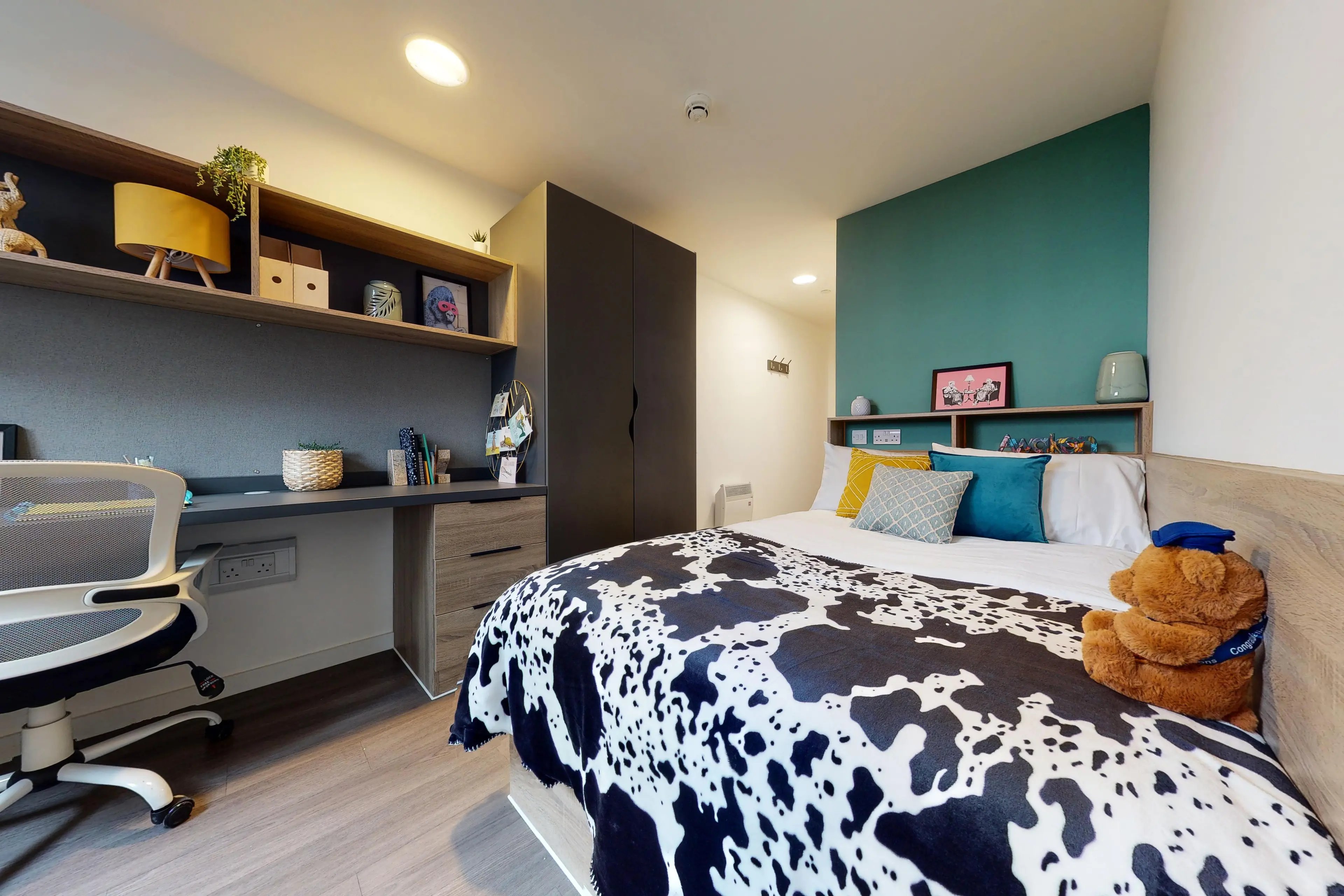 Bed with cow print blanket desk and chair Bedroom at Canvas Walthamstow in London Student Accommodation