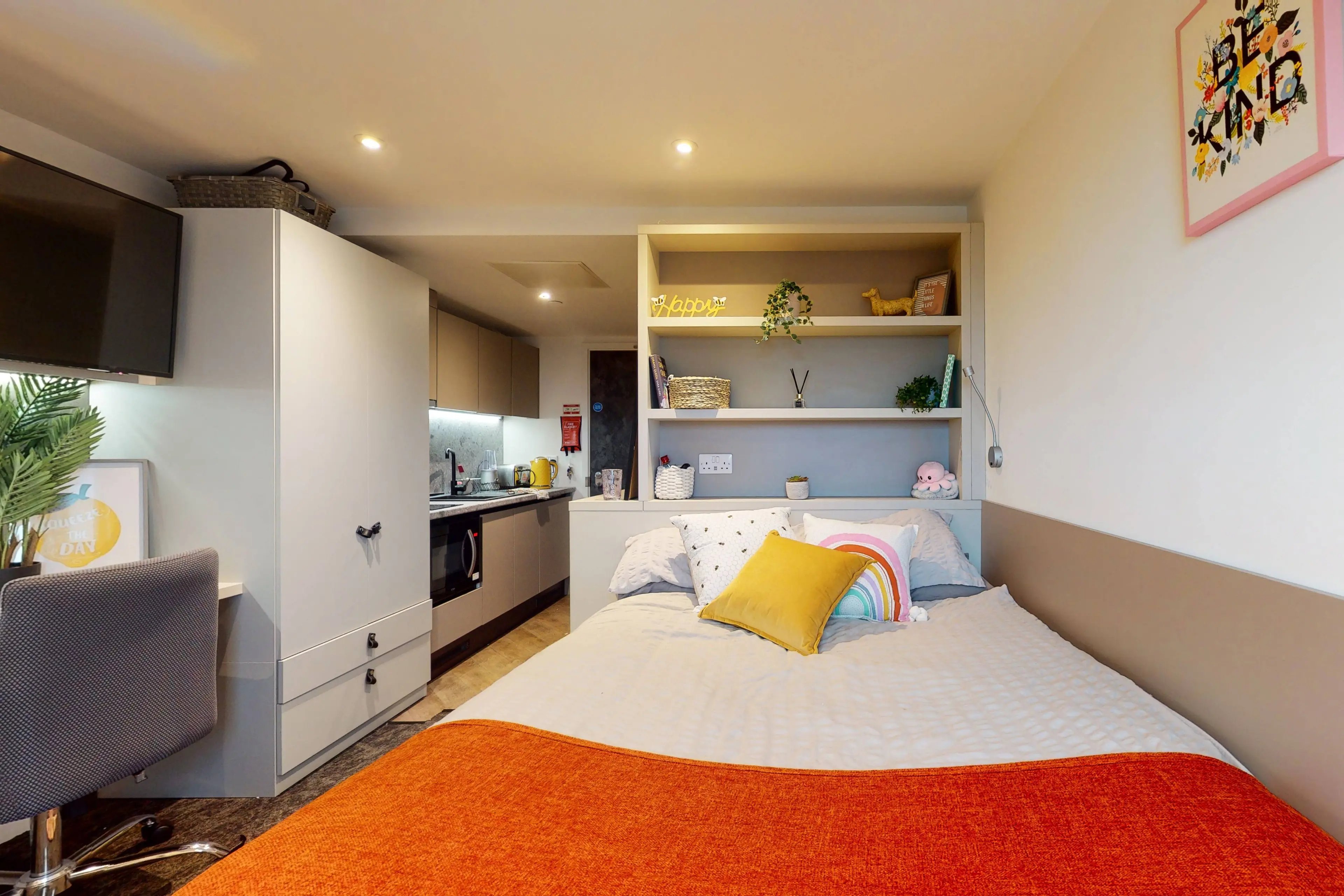 Bed desk kitchenette shelves and television bedroom at Canvas Manchester in Manchester Student Accommodation