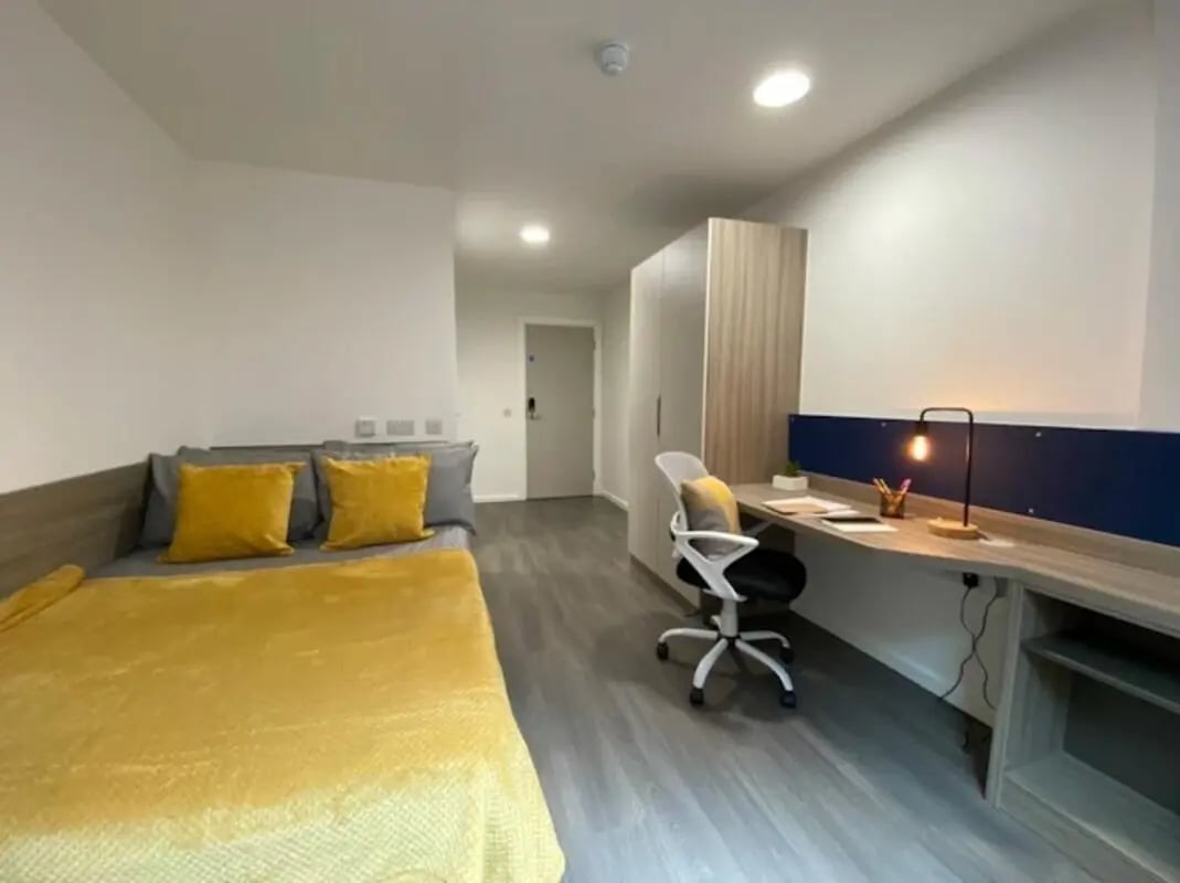 Bed desk wardrobe with yellow accents Bedroom at Hollis Croft in Sheffield Student Accommodation