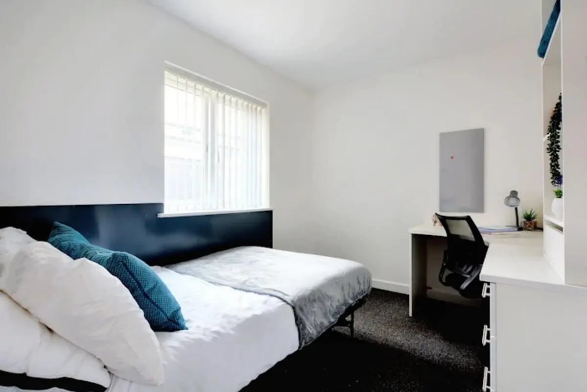 Bed pillows desk chair and shelves bedroom at Newarke Street Leicester in Leicester Student Accommodation