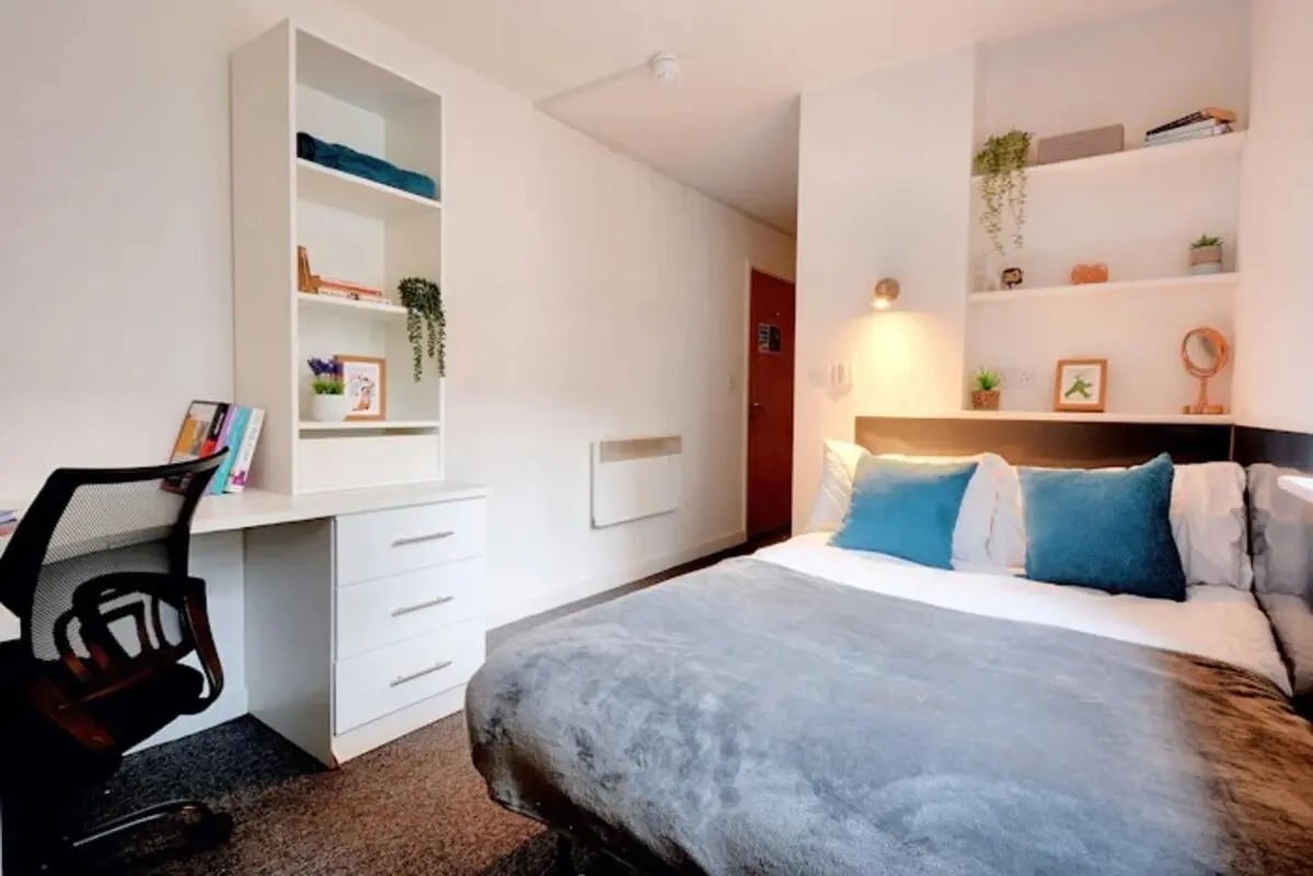 Bed desk chair shelves with books and plants bedroom at Newarke Street Leicester in Leicester Student Accommodation