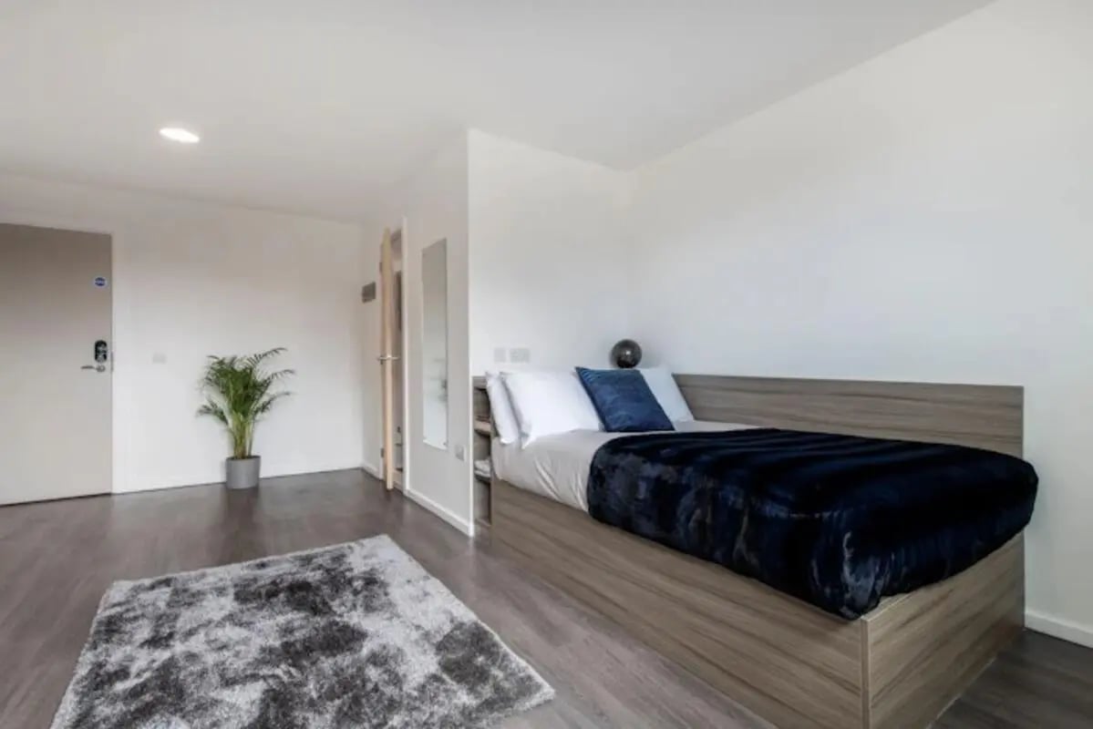 Bed with dark blanket and rug bedroom at Hollis Croft in Sheffield Student Accommodation