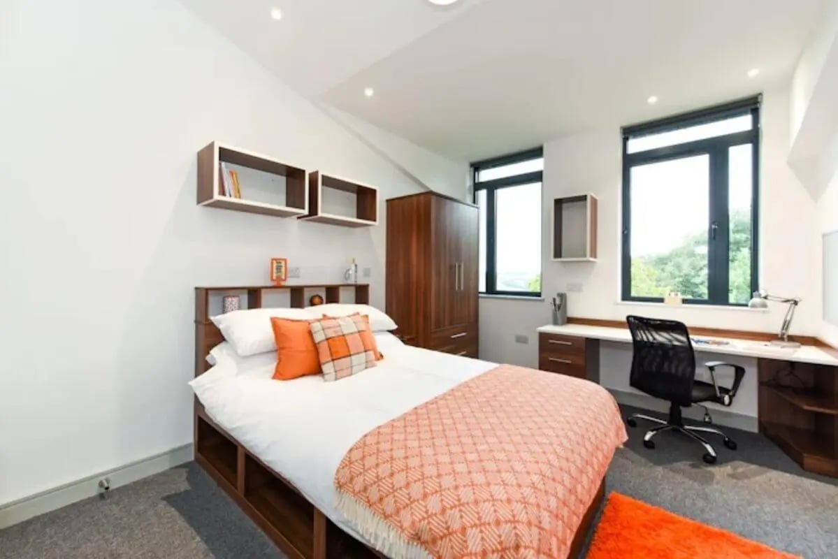 Bed desk wardrobe shelves and windows bedroom study area at Chapel Heights in Durham Student Accommodation