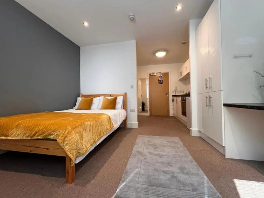 Bed kitchen cabinets and doorway studio apartment at Hydrogen in Nottingham Student Accommodation