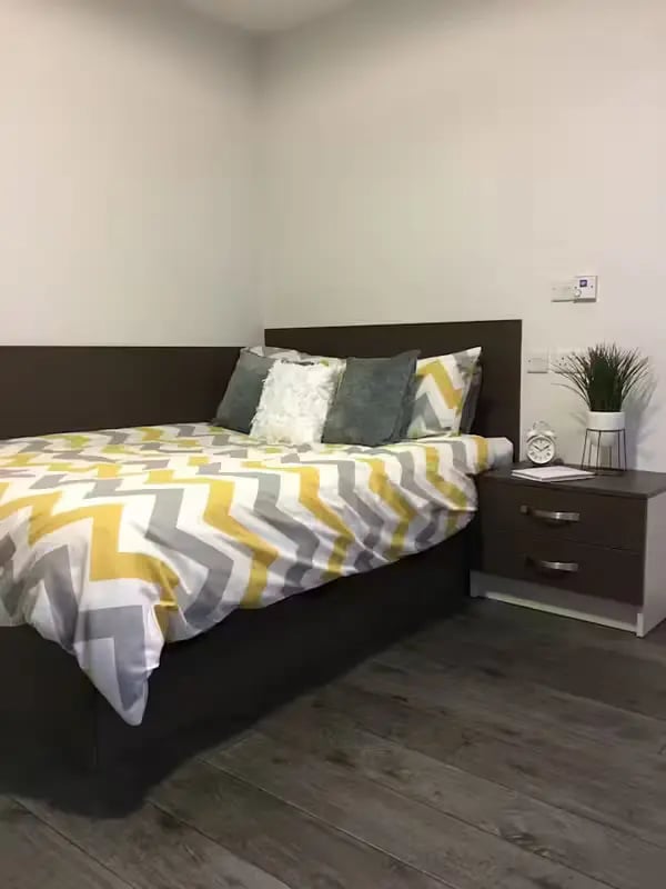 Bed with chevron bedding bedside table bedroom at Cornerhouse in Sheffield Student Accommodation