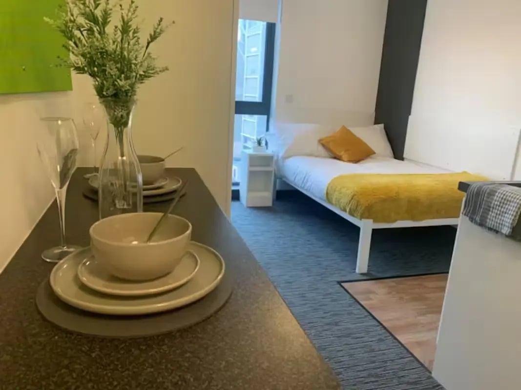 Table with dishes and bed bedroom at St James Point in Newcastle Upon Tyne Student Accommodation