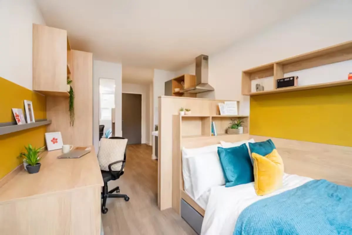 Desk bed and shelves with yellow accents bedroom at Hillfort House in Brighton Student Accommodation