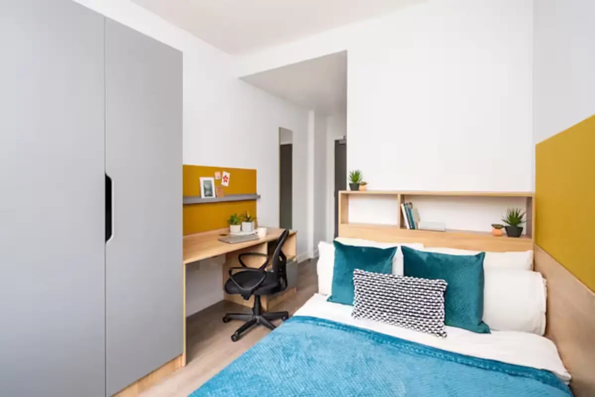 Wardrobe desk chair bed with cushions bedroom at Hillfort House in Brighton Student Accommodation